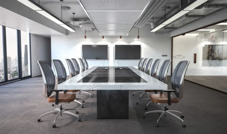 An image of a large boardroom, with multiple chairs and two wall screen 